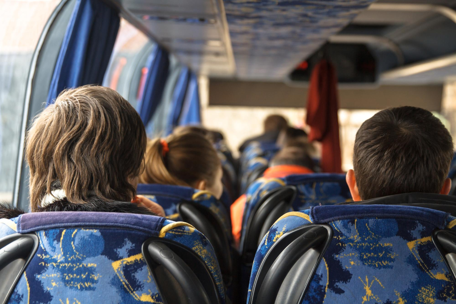 Niños sentados en autobús escolar desde atrás