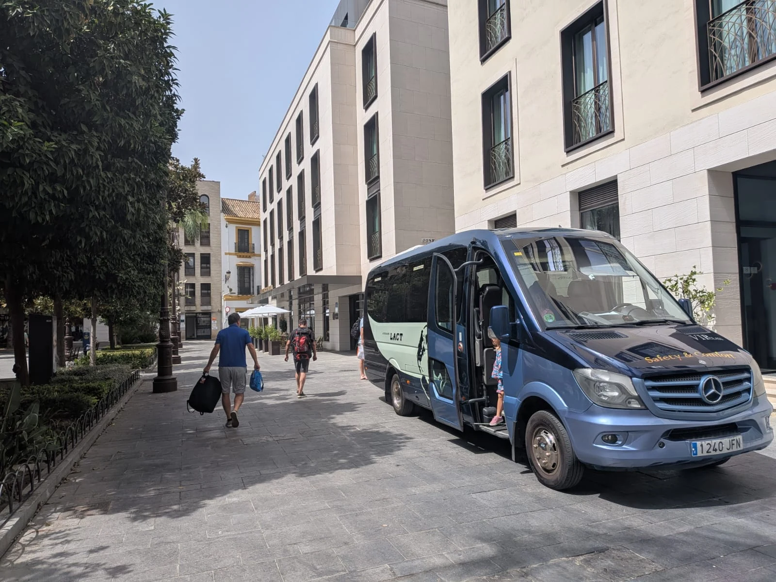 Minibús Mercedes de Autocares LACT realizando un servicio de traslado de pasajeros junto a un hotel.